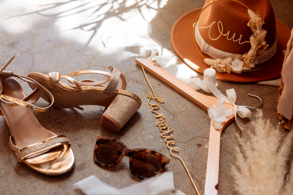 éléments de détails pris en photo par May Jolies Photo, photographe de mariage : chapeau, cintre, chaussures, lunettes, fleurs