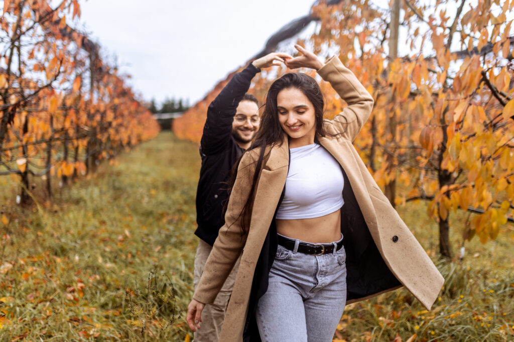couple qui danse sous la pluie dans un verger, couleurs chaudes et douces